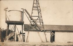 A Man Standing in Front of a Barn and Water Tank Porterville, CA Postcard Postcard Postcard