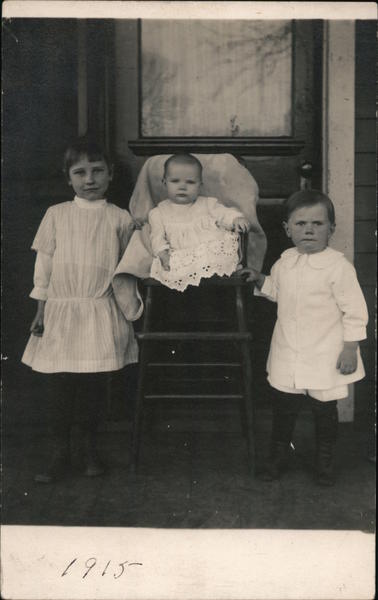 Three Children Posing On Porch Postcard