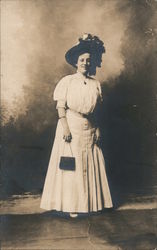 Studio photo of woman in white with purse and large hat Postcard