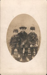 Three young boys sitting for photo Postcard