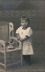 Child photo with doll in chair Postcard