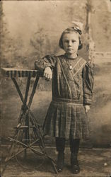 Studio portrait of young girl leaning on wooden table made with branches Children Postcard Postcard Postcard