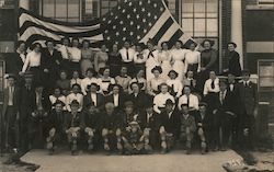 Large group photo of men and women in front of over-sized U.S. Flag Postcard