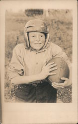 Boy wearing football helmet and holding football Postcard