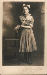 Girl with dress and hairbow, posing by chair Children Postcard Postcard Postcard