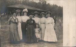 Women gathered around matriarch with child and doll Postcard