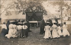 Group of Ladies kneeling outside in front of a tent Postcard