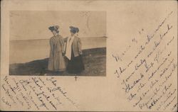 Two girls walking along the beach Postcard