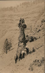 People posing with tall rock formation on side of mountain Landscapes Postcard Postcard Postcard