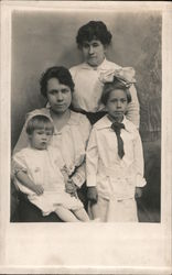 Two Adults and Two Children posing for a portrait Postcard