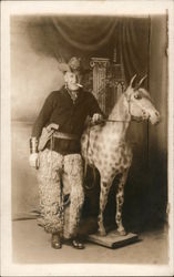 Man in Cowboy attire posing with horse statue Postcard