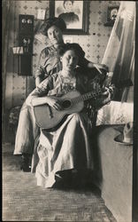 Two women with one playing a guitar Postcard