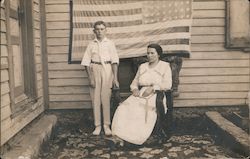 Young Boy and Woman behind Upside Down American Flag Postcard