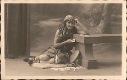 Female Gypsy Fortune Teller leaning against bench Postcard