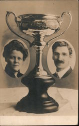 Portraits of man and woman next to a trophy Postcard