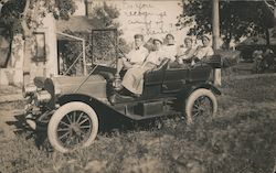 Family sits in car near house Postcard