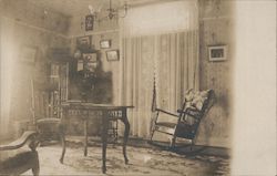 Parlor View with rocking chairs and a table. Postcard