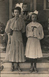 Three young people posing outside a building Postcard