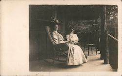 Two women sitting on a covered porch Postcard