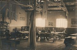 People in uniform sitting at tables inside a building Postcard