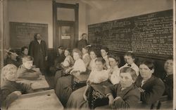 Students and teachers pose in a classroom with blackboards filled with math School and Class Photos Postcard Postcard Postcard