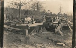 People examine the ruins of a damaged building Postcard