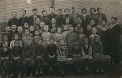 Group of children posing outside, with a teacher Postcard