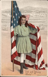 Young girl holding a flag draped behind her. "Old and Young Glory" Military camp in the background. Patriotic Postcard Postcard Postcard