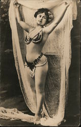 A woman dressed in beads holds draping cloth above her head Circus Postcard Postcard Postcard