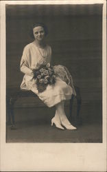 A Woman Posing with a Bouquet of Flowers Postcard