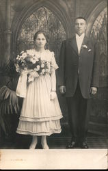 A Bride Holding Flowers Next to a Groom Postcard