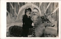 A Little Girl Sitting on a Reindeer Next to Santa Santa Claus Postcard Postcard Postcard