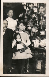 A Girl Holding a Doll in Front of a Tree with her Parents Children Postcard Postcard Postcard