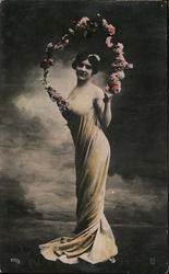 Woman in see through sheath holding arch of flowers Postcard