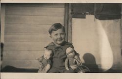 A boy with two dolls in front of a house Children Postcard Postcard Postcard