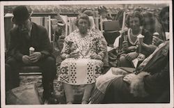 Tourists sitting on chairs on beach eating ice cream cones Postcard