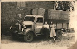 Little girl on hood of truck as man and women pose by truck with Pirmasens sign Germany Trucks Postcard Postcard Postcard