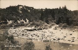 Beach, bathers, canoes, mountain, river bend Postcard