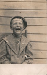 Laughing boy sitting in chair missing teeth Postcard