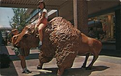 Bison - Two girls climb on a bison sculpture on the Mall at The Landing Kansas City, MO Postcard Postcard Postcard