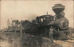 Man standing next to logging steam train Postcard