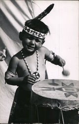 Boy with headband and necklace plays decorated drum Postcard