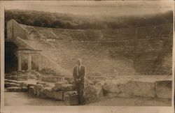 Tourist poses in front of stone amphitheater ruins Postcard