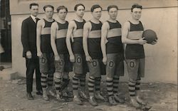 six male basketball players with shorts displaying "O" - Manager also pictured Postcard