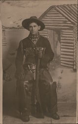 Man Dressed as Cowboy - Sitting Down and Holding a Rifle Postcard