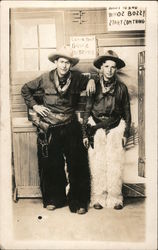 Two Men dressed as Cowboys outside a Sloon Postcard